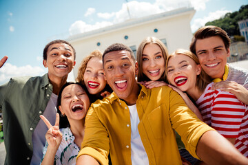 Group of cheerful friends enjoying their summer day together outdoors in a vibrant urban setting...