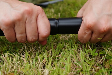 Close-up of hands connecting a black pipe. Concept of repair, installation, engineering or plumbing...