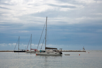 Sailboats anchored in Novigrad harbor with lighthouse view, Croatia.