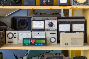 Vintage analog and digital meters on a shelf. Retro electronic and measuring equipment from the...