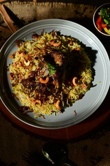 Mutton Mandi Rice. A close-up, overhead shot of a delicious, savory dish served in a rustic bowl, garnished with fresh herbs and spices.