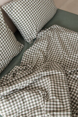 Green bed linen made of boiled cotton. Plaid pillowcases and duvet cover. Fabric closeup