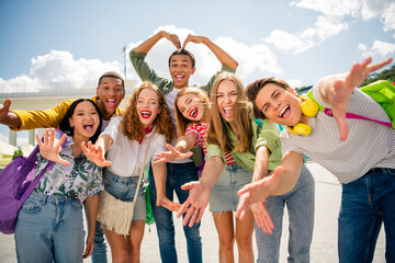 Group of cheerful young friends enjoying a sunny day outdoors, celebrating friendship, happiness