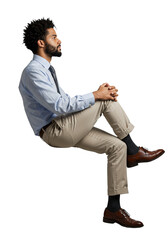A man in a blue shirt and tan pants sits with his hands clasped isolated on transparent background