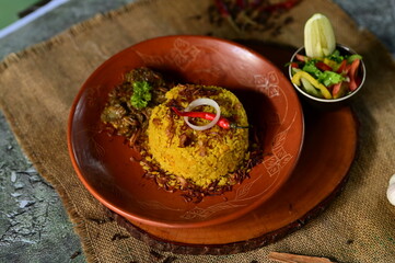 A beautifully presented Beef Khichuri With Green Salad dish with a side of salad and a lemon wedge,...