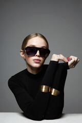 blond girl in glasses and bracelet