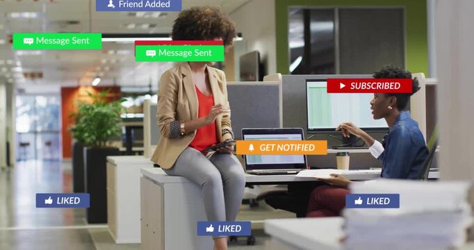 Women pointing at tablet in office, animating social media notifications appearing then fading
