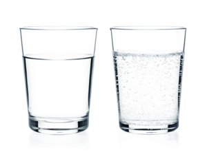 Clear water and sparkling water in glass cups on white surface