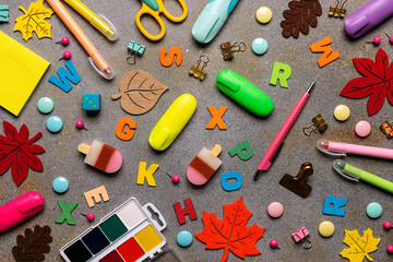 Seamless pattern with colorful stationery set on dark rustic background. Back to School concept background, top view.