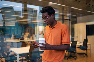 Young professional checking phone in modern office