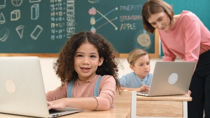 Attractive girl coding prompt while looking at camera at STEM class while happy teacher checking...