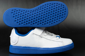White and blue casual shoes with unique sole design displayed prominently