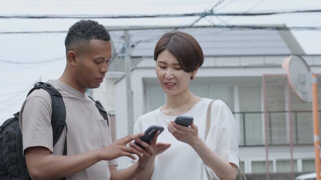 スマホ翻訳アプリで外国人に道案内する女性
