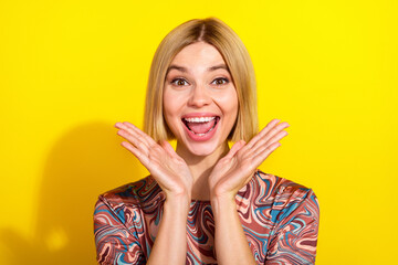 Cheerful young woman smiling against a vibrant yellow background, expressing joy, positivity, and...