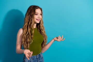 Charming young woman in casual attire gesturing expressively on a vibrant blue background