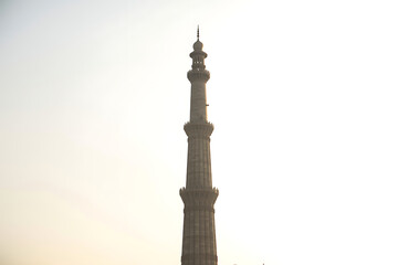A stylized white minaret with palm trees stands against a bright sky, perfect for representing travel or cultural themes.