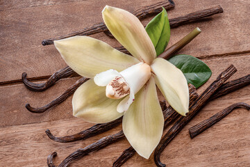 Yellow moth orchid flower and vanilla sticks on wooden table. © volff