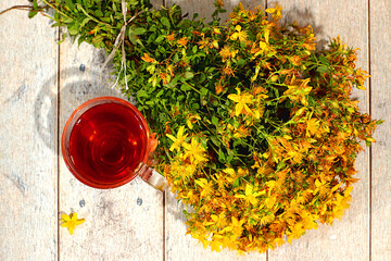 St. John's wort infusion in a glass with flowers, Medicinal herbal tea, alternative folk medicine...