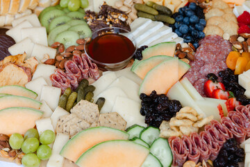 Colorful charcuterie board featuring a variety of meats, cheeses, fruits, and nuts prepared for a gathering