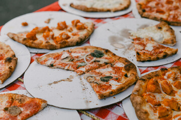 Delicious slices of pizza on display at a lively outdoor gathering in the afternoon sunshine