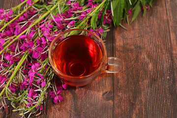 Medicinal herbal tea or fireweed infusion in a glass with flowers, alternative folk medicine concept, green pharmacy advertisement, collection of useful herbs for treatment according