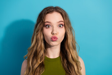 Playful young woman with a surprised face gesture against a vibrant blue background showing a fun...