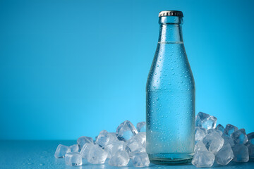 Refreshing water bottle with ice cubes on a blue background still life