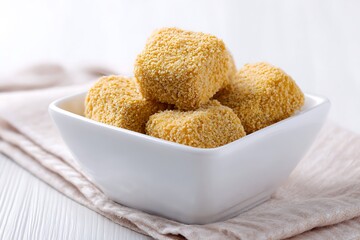 Golden Chicken Nuggets in White Bowl on Neutral Fabric Background Close Up