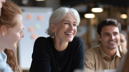 Happy mature old female mentor coach supervisor training young interns at group office meeting professional workshop. Smiling middle aged teacher professor laughing with students at university class,