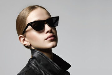 pretty blond girl in black glasses and leather coat