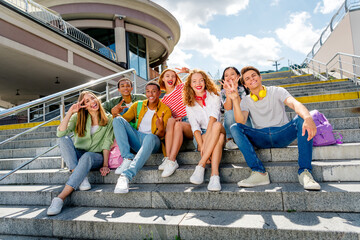Friendly young friends enjoying sunny day outdoors in urban setting
