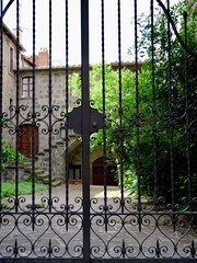 Old metal gate and narrow street in the Medieval old town of Viterbo. Viterbo, Lazio region, Italy