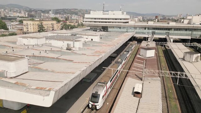 Tbilisi, Georgia - 11th july, 2025: aerial view Modern Stadler FLIRT electric train stands at Tbilisi Station Square with passengers boarding for Batumi departure.Ecological sustainable travel Europe