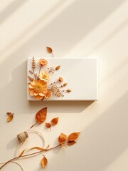 Autumn floral arrangement with blank frame and natural decorations on a textured surface against a light gradient