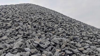 Close-up view of a large pile of crushed stones or gravel, used in construction and road building,...