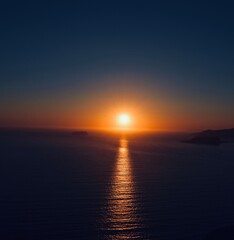 Stunning ocean sunset with vibrant orange and blue sky reflecting on calm water.