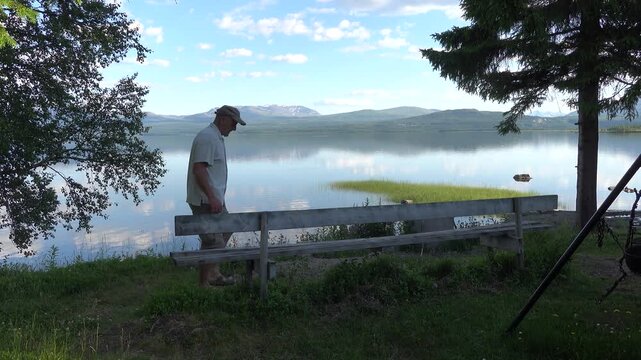Klocka, Sweden A man sits on a bench by the remote &Aring;nnsj&ouml;n Lake in the J&auml;mtland region.