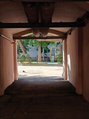 Pathway leading to a vibrant courtyard with greenery and playground equipment during daytime