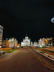 Night view of a beautiful central square featuring a remarkable building illuminated by street lights