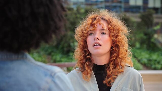 A candid moment capturing two women in a passionate dispute, highlighting their intense emotions and expressive gestures while discussing a troubling issue that has caused significant tension between