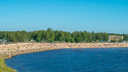 Finland. Sandy beach of Oulu city. Many people relax on a hot summer day on the sea beach.