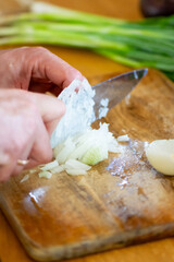Chopping Green Onions on Rustic Wooden Cutting Board
