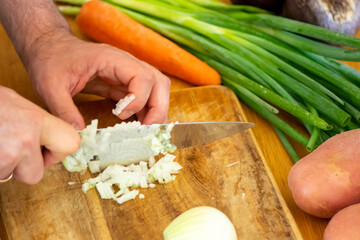 Chopping Green Onions on Rustic Wooden Cutting Board