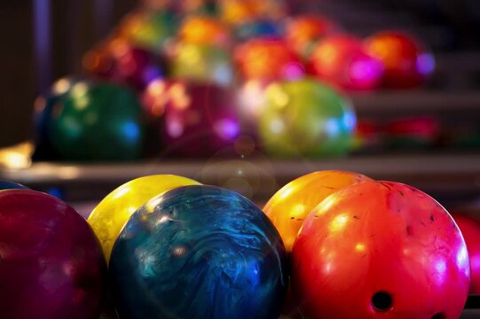 Slow moving background of bowling balls prepared on a rack in a bowling alley. Zoom-in. Modern bowling alley with futuristic design