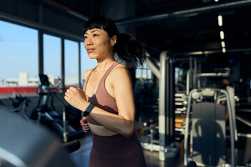 Woman Running on Treadmill in Gym During Morning Workout Routine