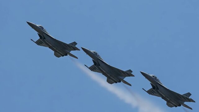 Three military fighter jets flying in tight formation in the blue sky. Aerial view with light clouds and vapor trails. Cinematic and photorealistic flight scene.