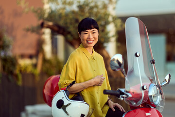 Smiling Woman Poses Outdoors with a Scooter on a Sunny Day