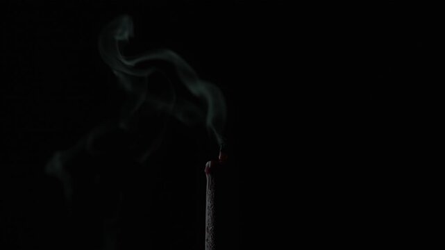 Wind puts out candle flame in darkness closeup. Bright fire on wax taper night