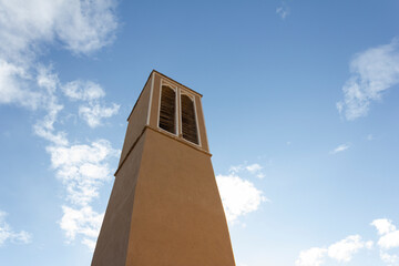 Historic windcatcher in Yazd, Iran, stands tall against a vivid blue sky—an iconic example of ancient Persian architecture and sustainable design.