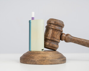 Judge's gavel and e-cigarette. Smoking ban. Tobacco heating systems. 
